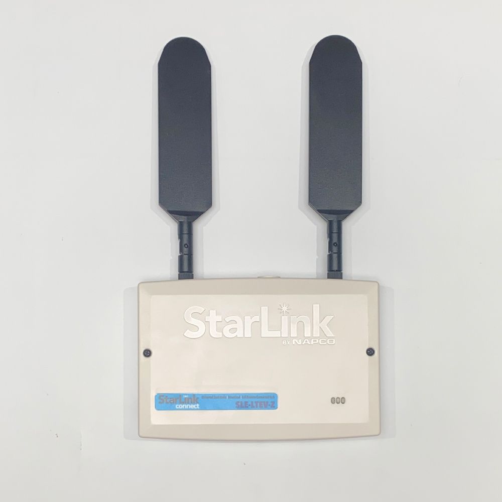 StarLink cellular communicator with two black antennas, mounted on a white wall.