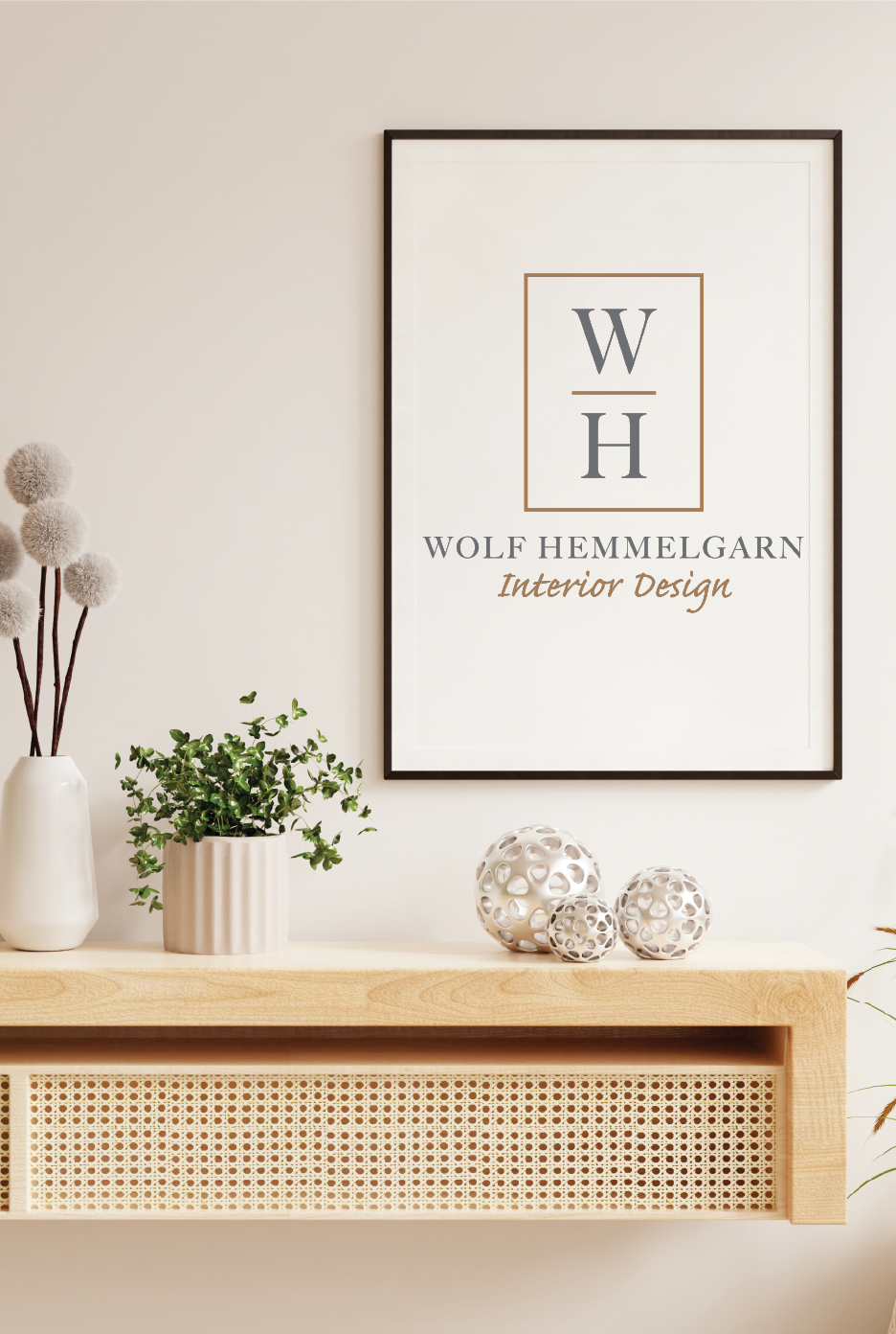 A framed logo for Wolf Hemmelgarn Interior Design, above a shelf with decor.