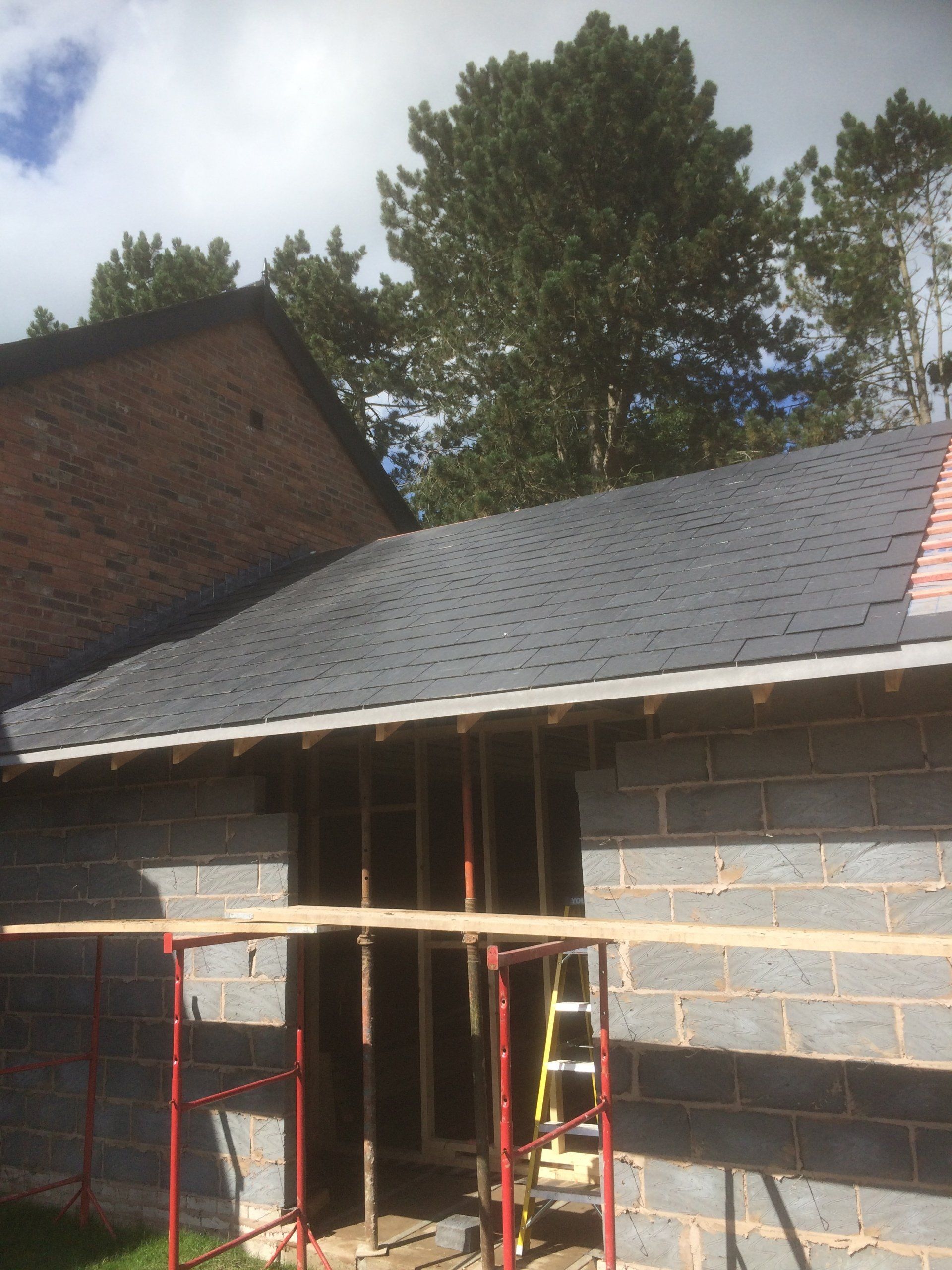 A brick building with a roof that is being built
