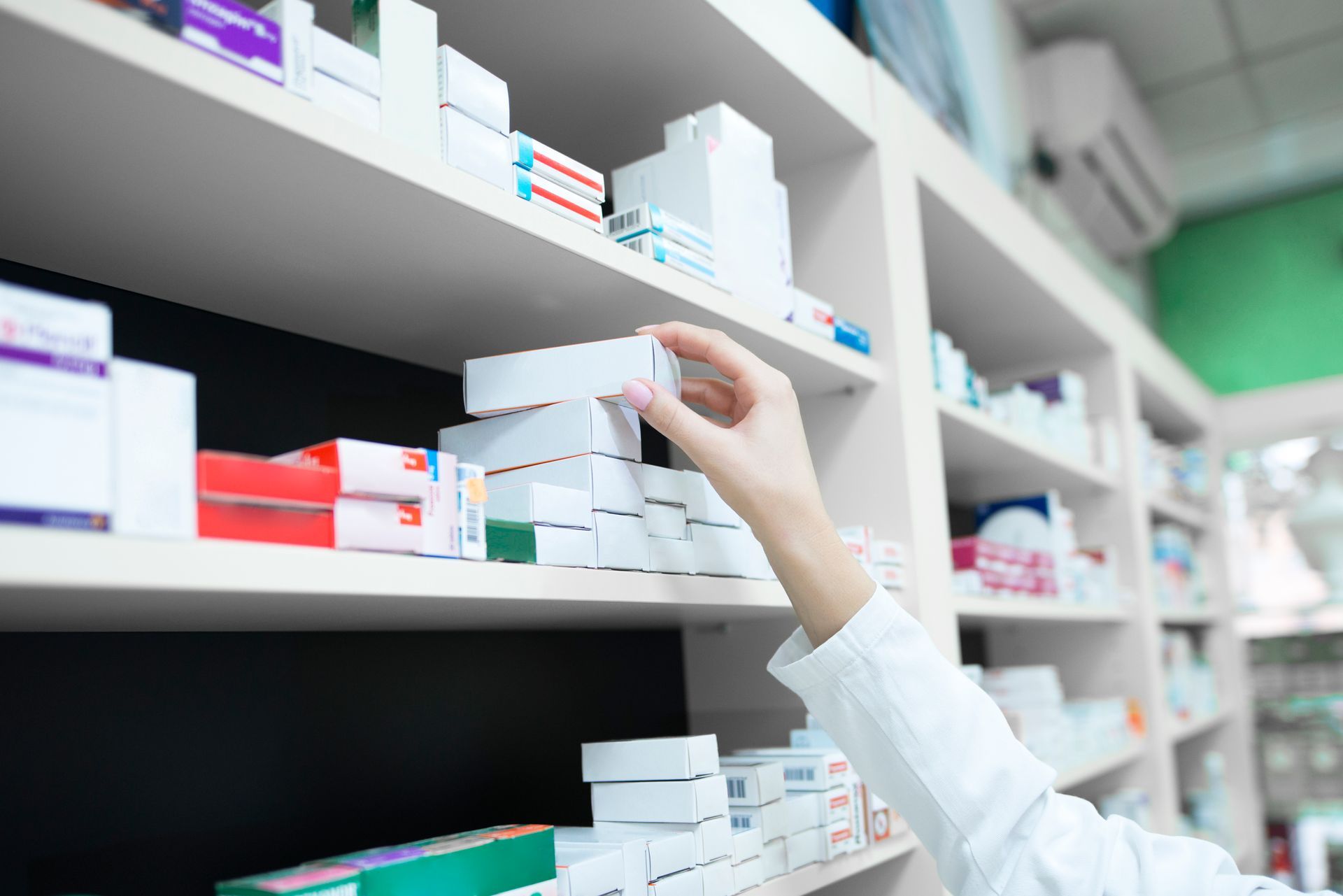 Farmacêutico pegando caixa de remédio.