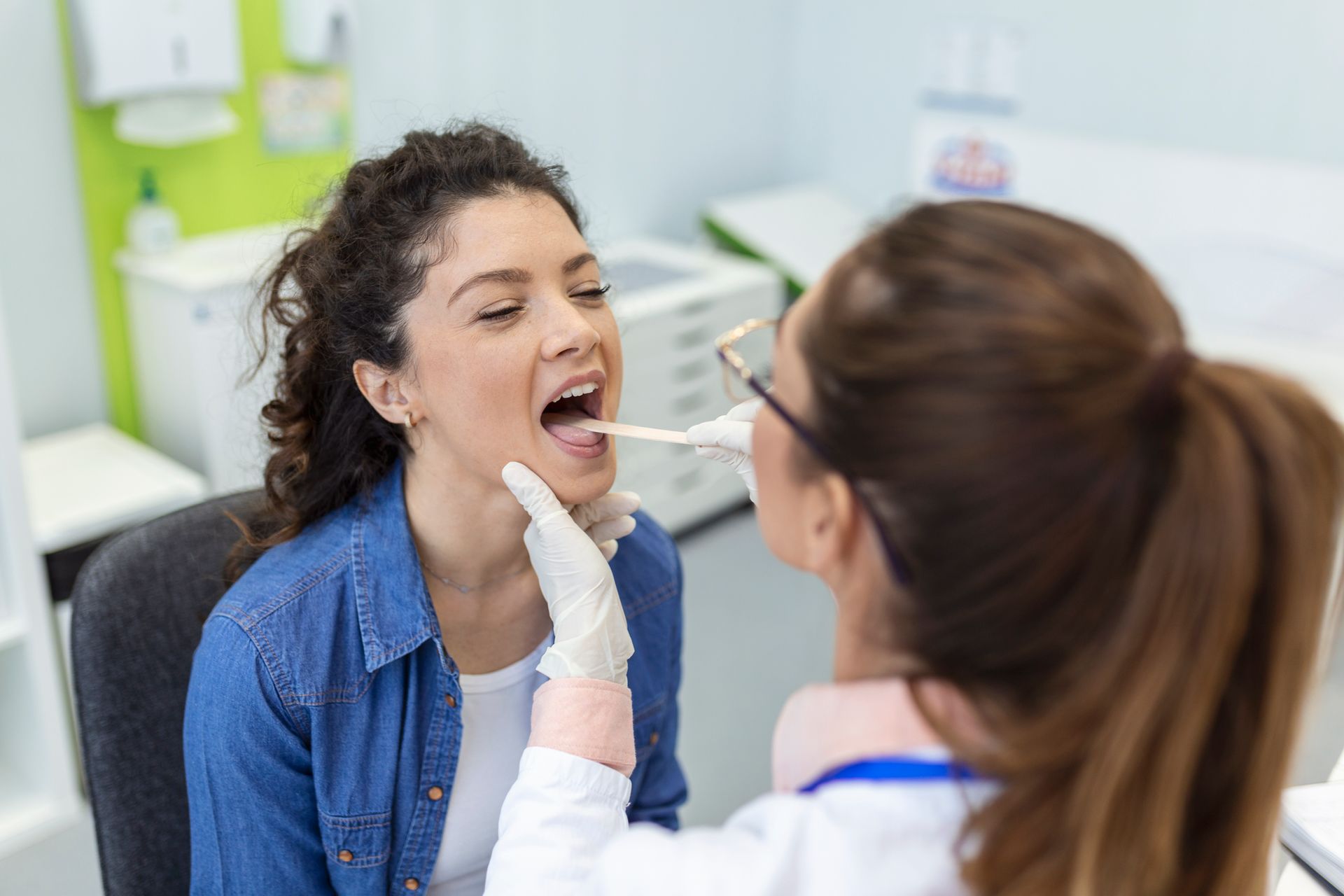 médica examinando a garganta da paciente