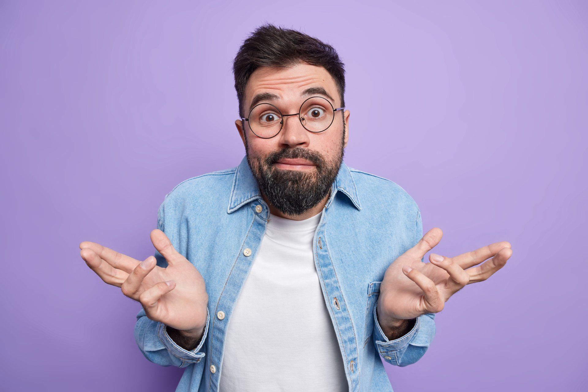 Homem jovem com barba e óculos, com expressão de dúvida