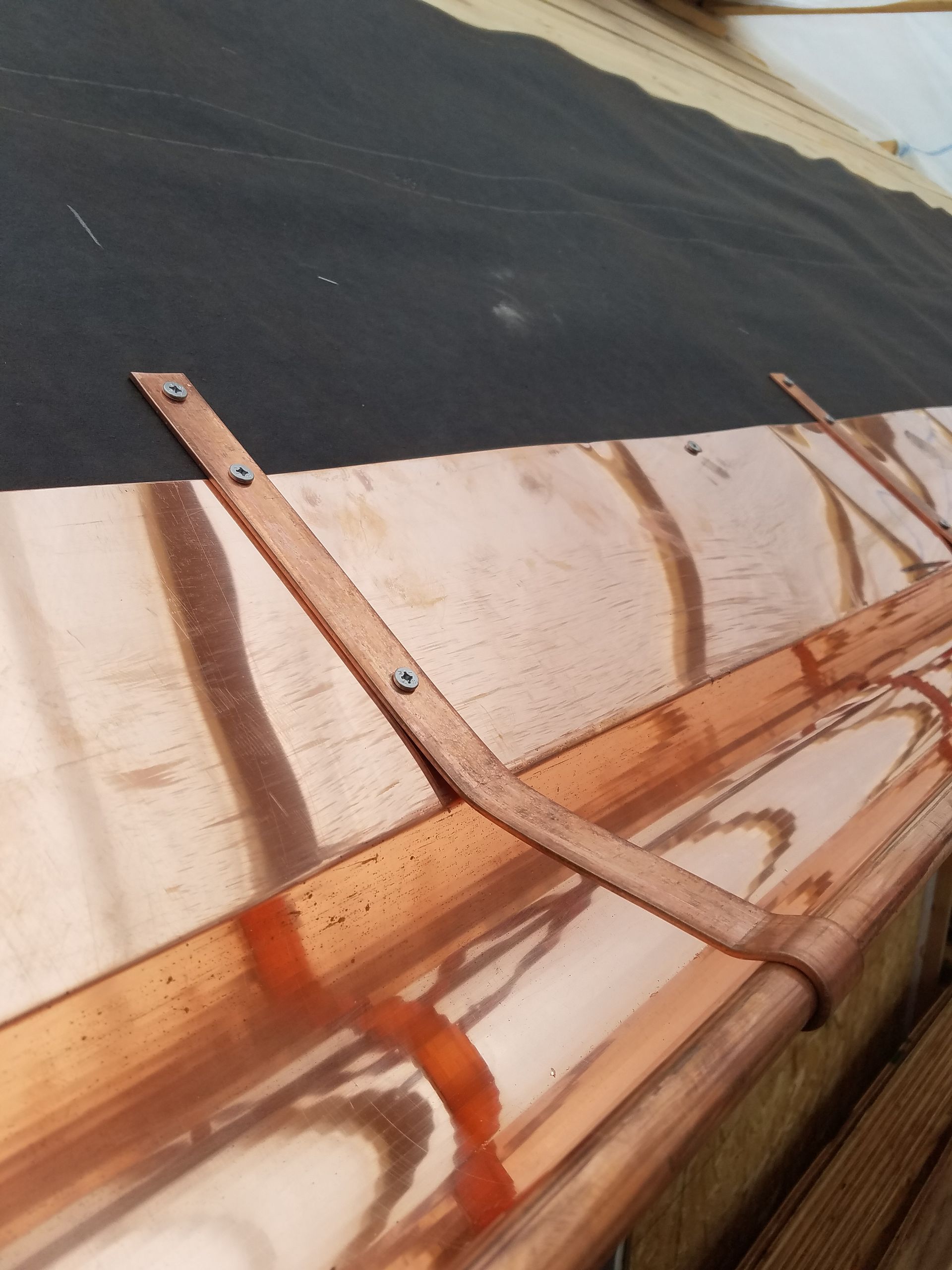 A close up of a copper gutter on a roof