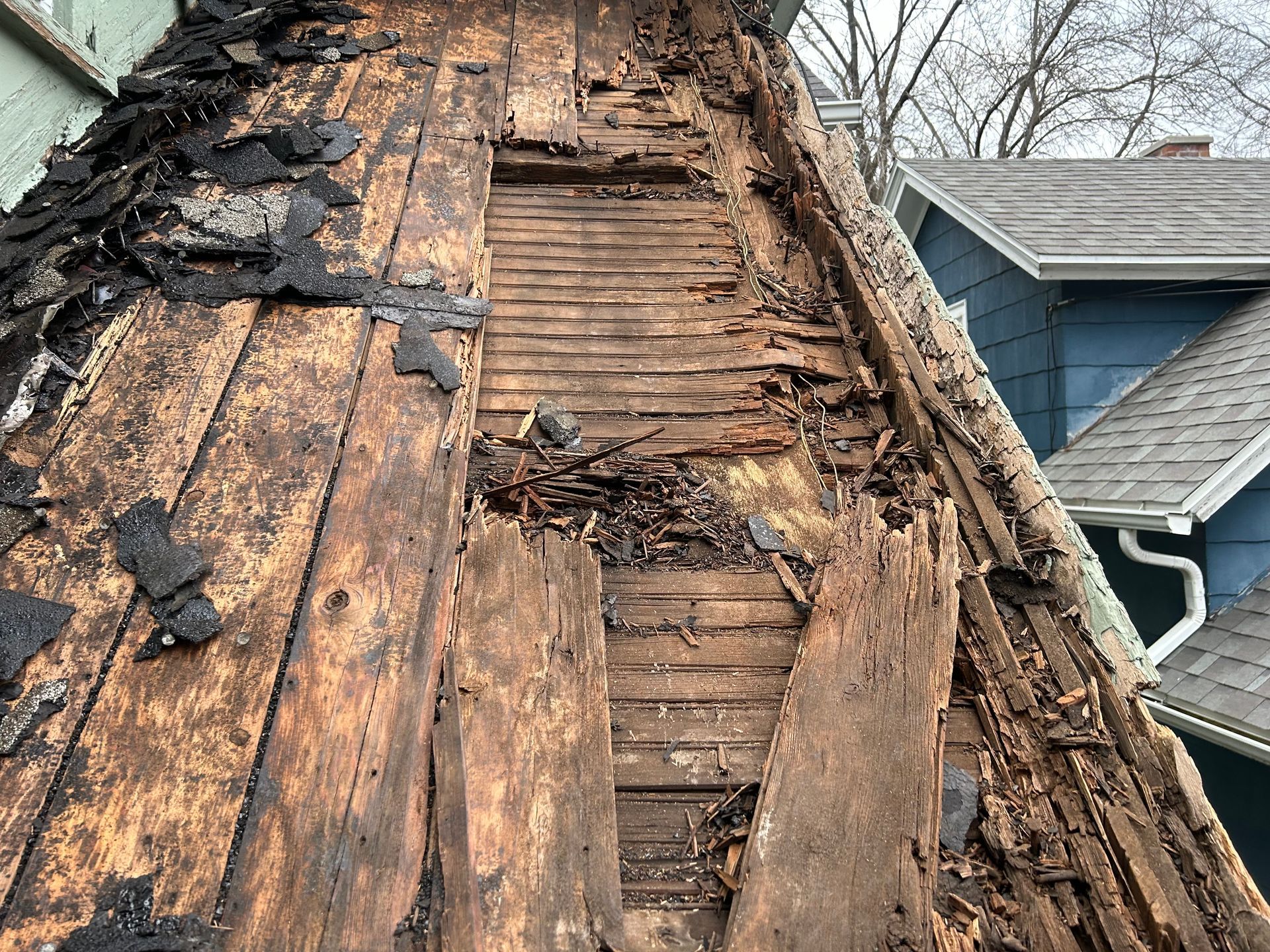 A close up of a roof with a lot of wood missing.