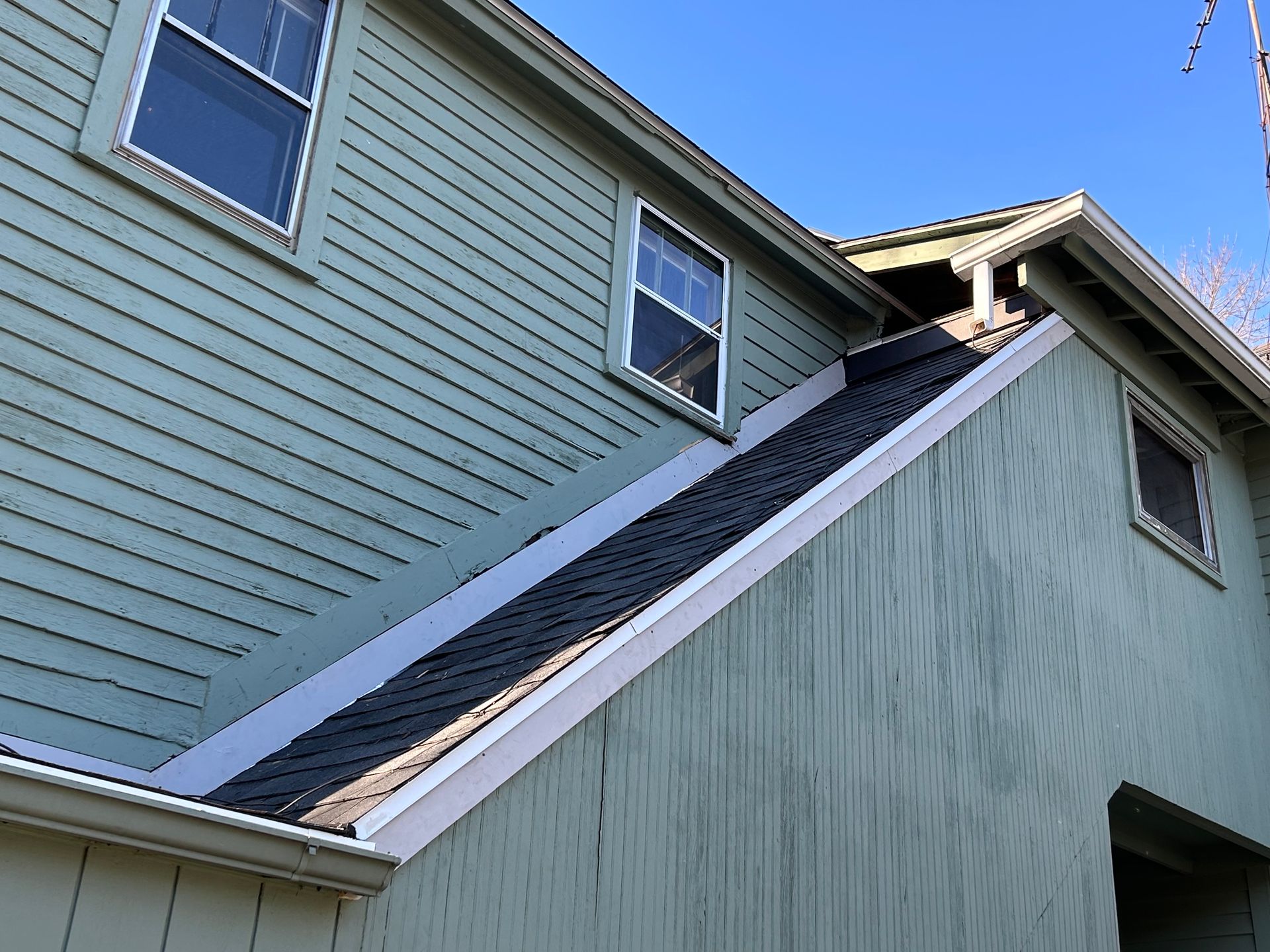 A green house with a roof that is very steep