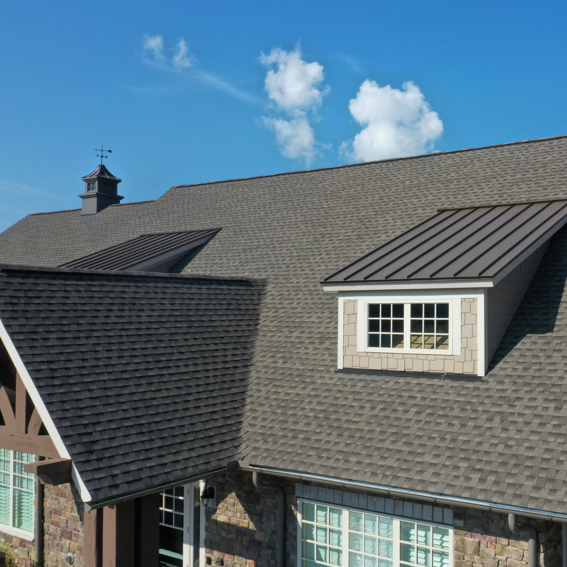 An aerial view of a house with a gray roof