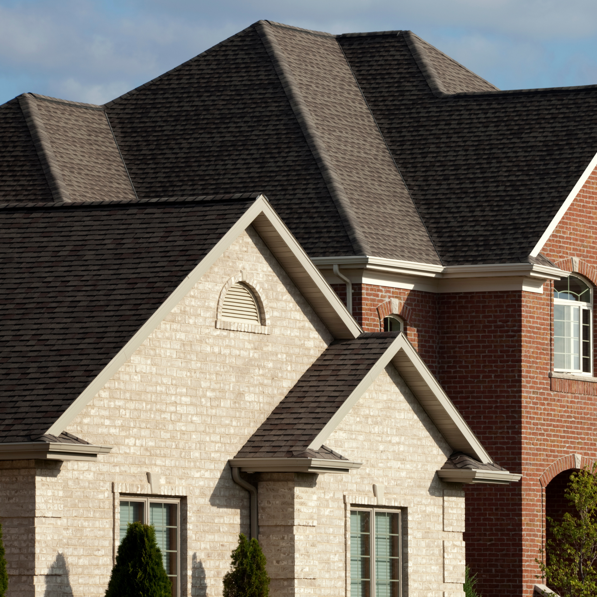 A large brick house with a black roof