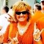 Woman in orange shirt and sunglasses, giving a Woman in orange shirt and sunglasses, giving a