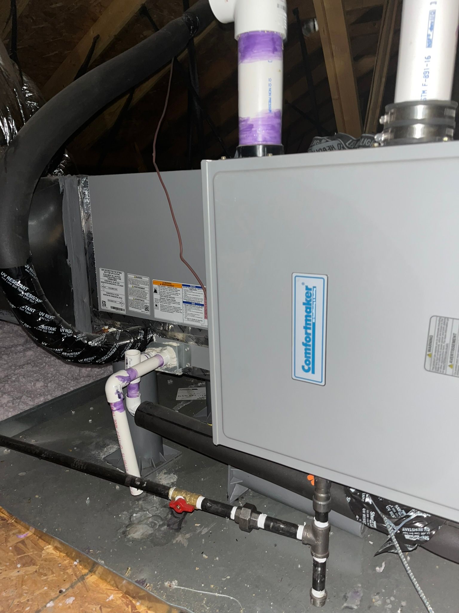 A person is cleaning an air conditioner with a high pressure washer.