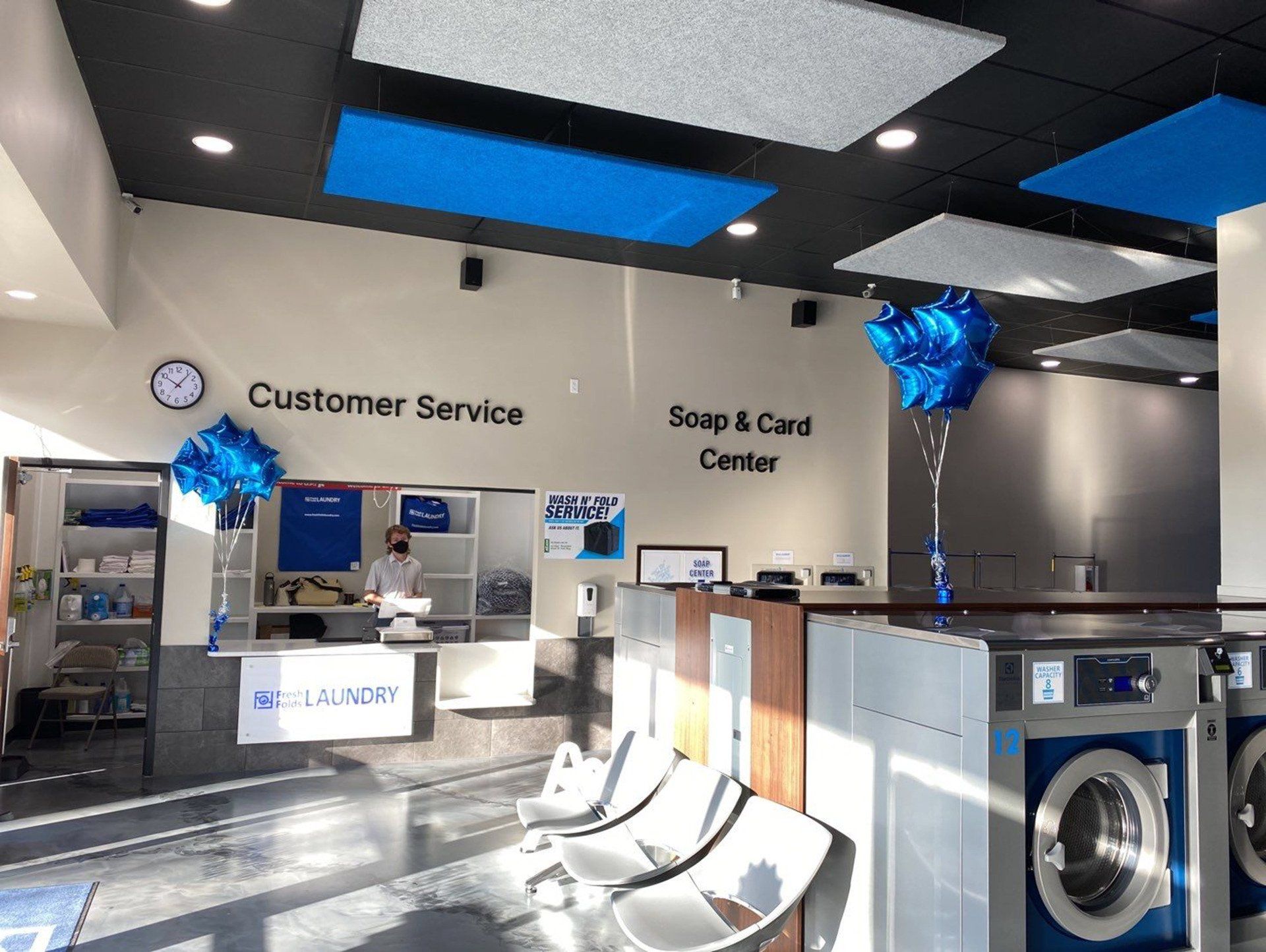Commercial interior remodel of a modern laundromat with customer service counters, updated machines and bright finishes by ARDS Contracting in Seattle.