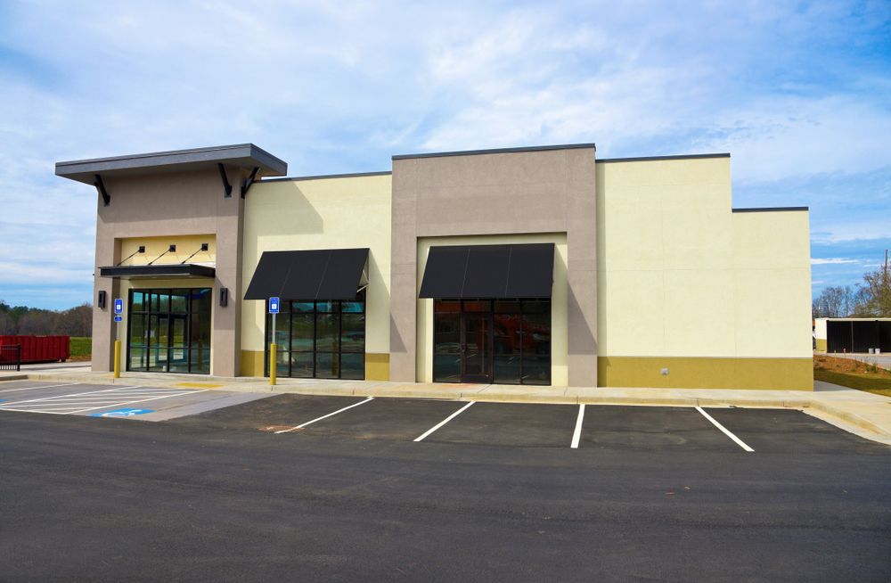 Commercial Building With Glass Windows, Awnings, and Accessible Parking Spot — Kellie O'Malley Conveyancing In Newcastle, NSW