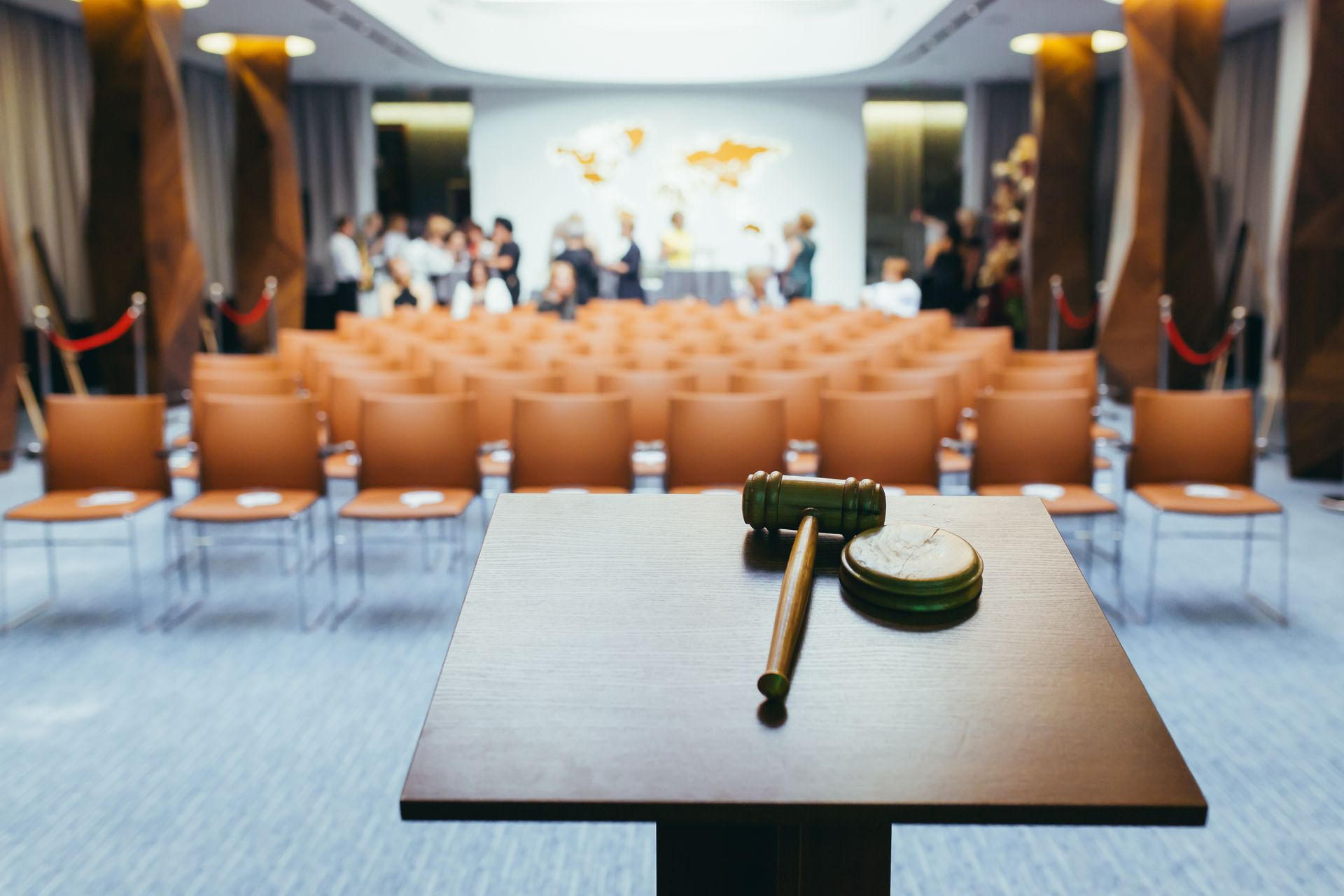 A Gavel and Pen on a Table in Front of an Empty Auditorium — Kellie O'Malley Conveyancing In Lake Munmorah, NSW