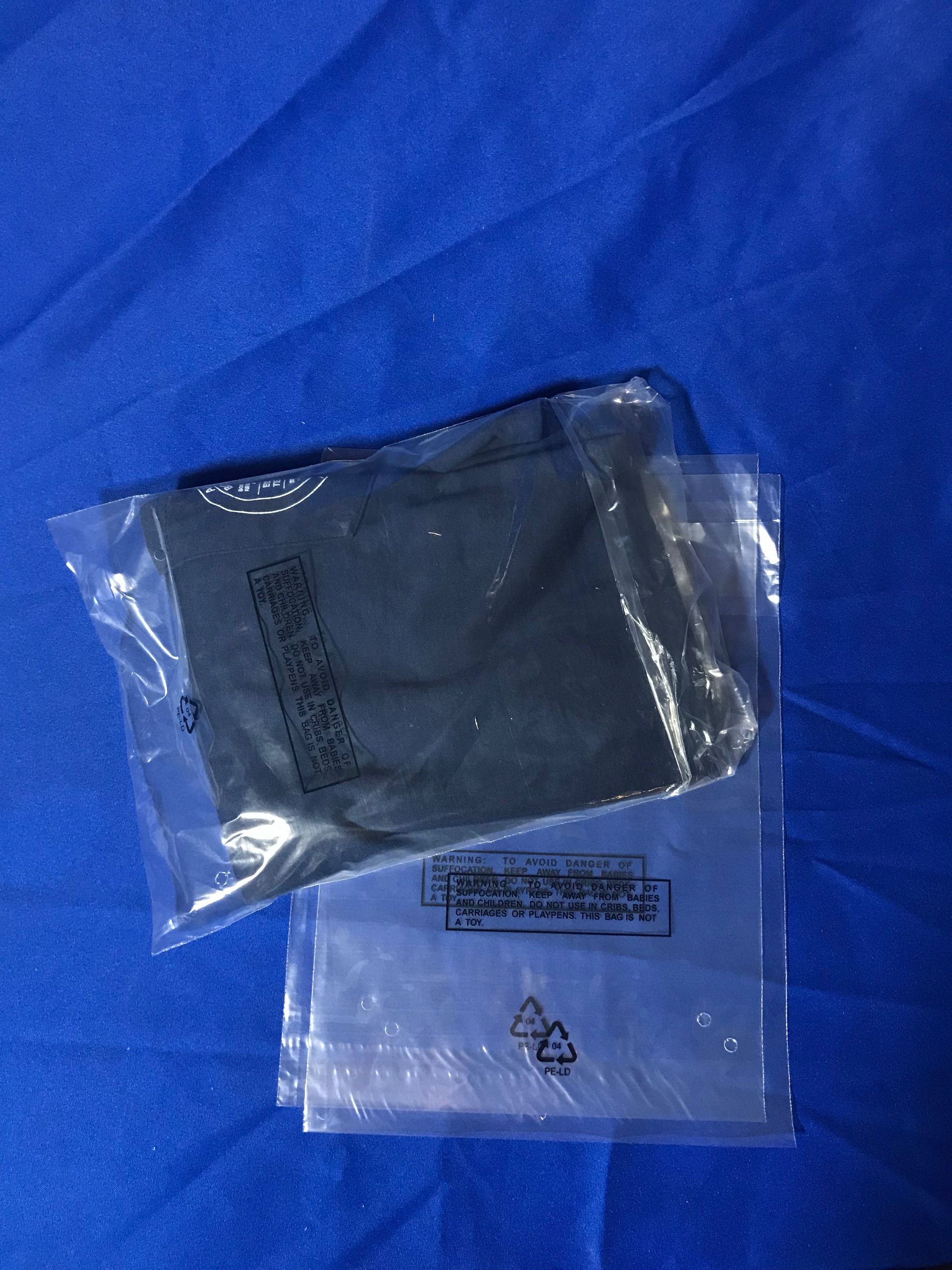 Two clear plastic bags and a black cloth pouch on blue fabric.