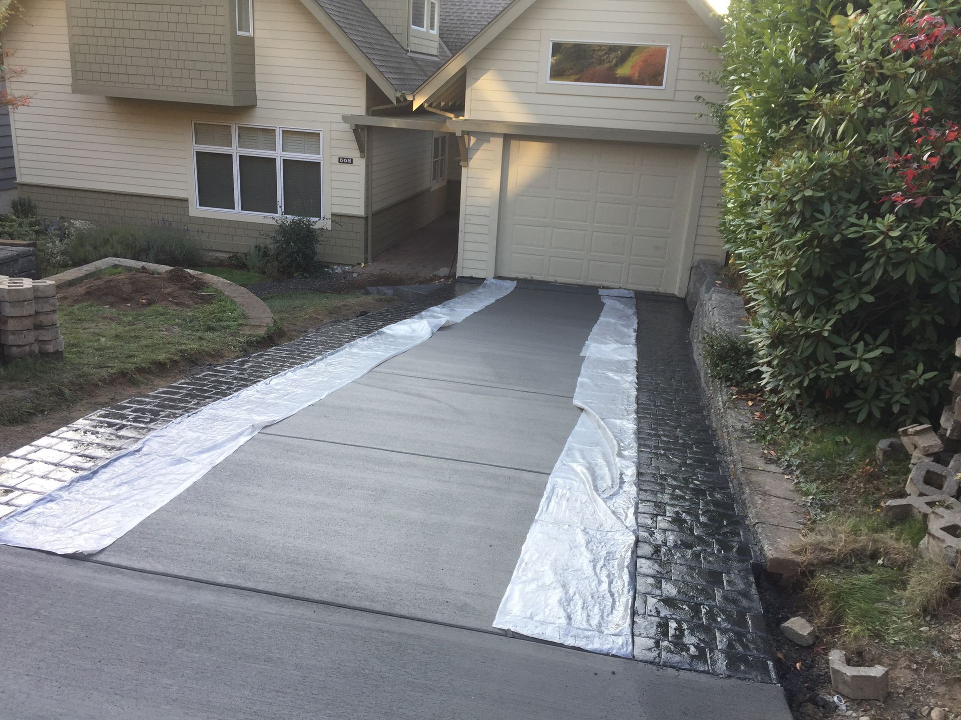 A concrete driveway is being built in front of a house