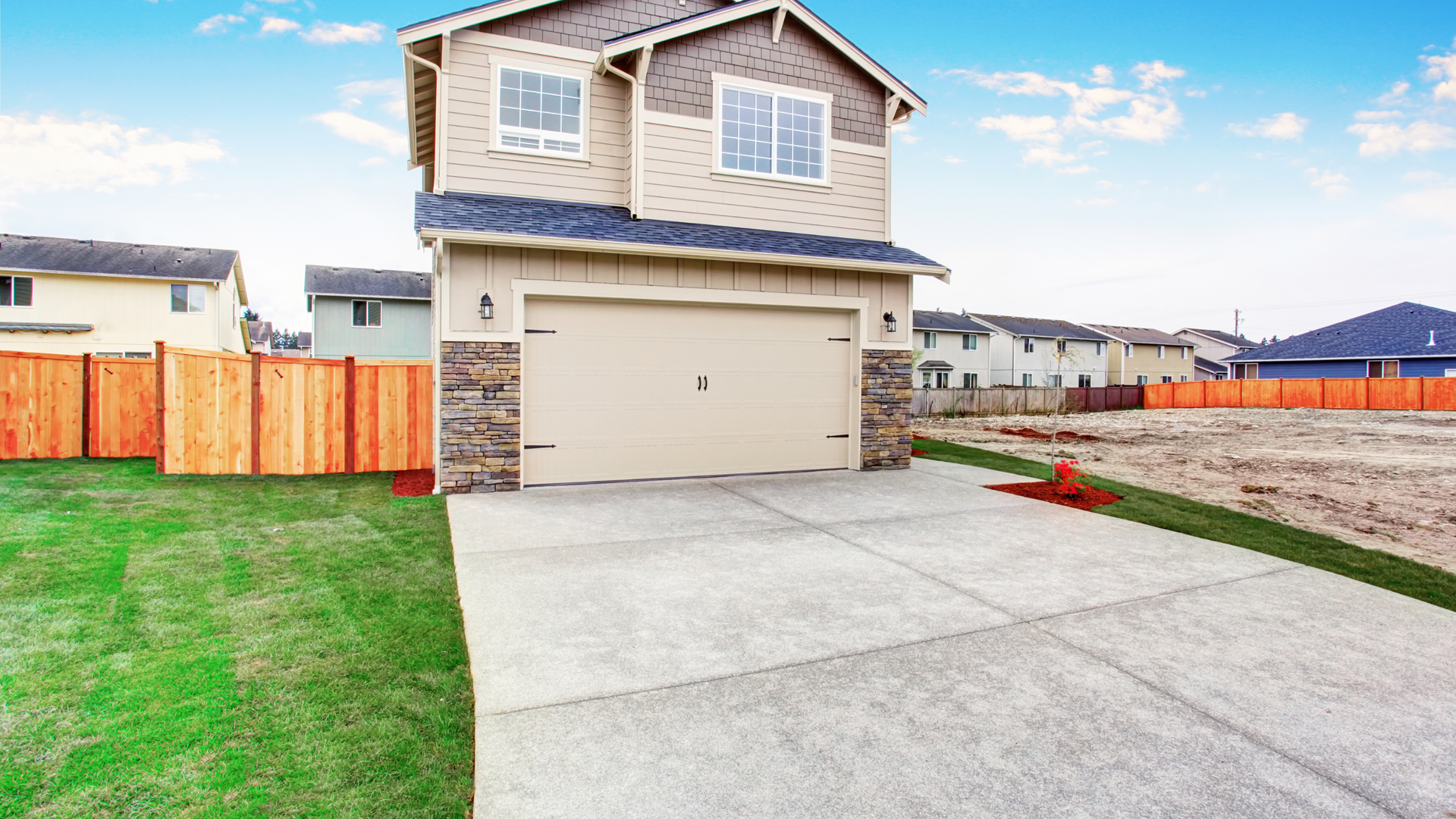 New concrete driveway installed at a residential home in a suburban neighborhood.
