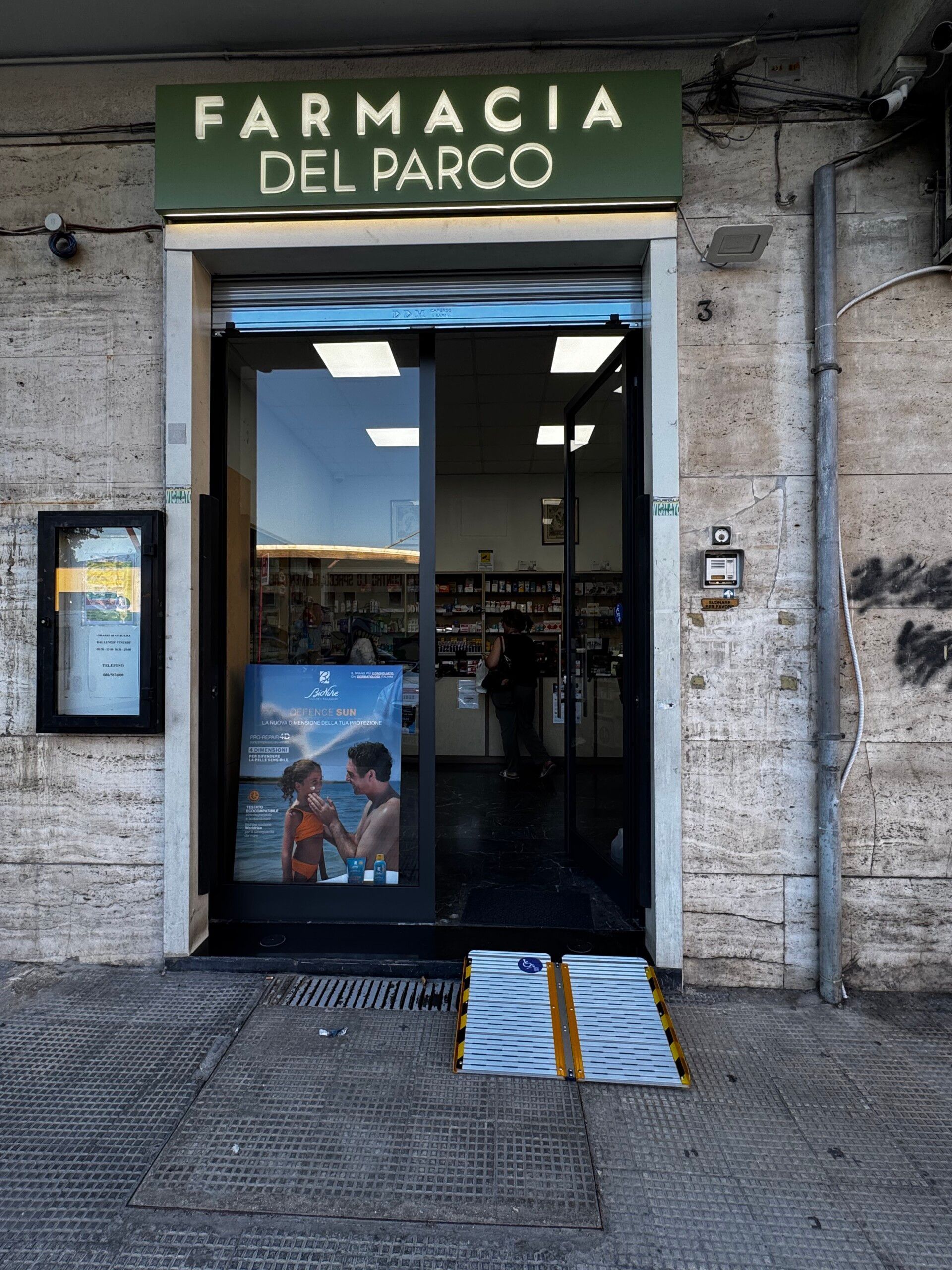 Rampa mobile davanti all’ingresso della Farmacia del Parco, attività aderente al progetto #IoRampo.