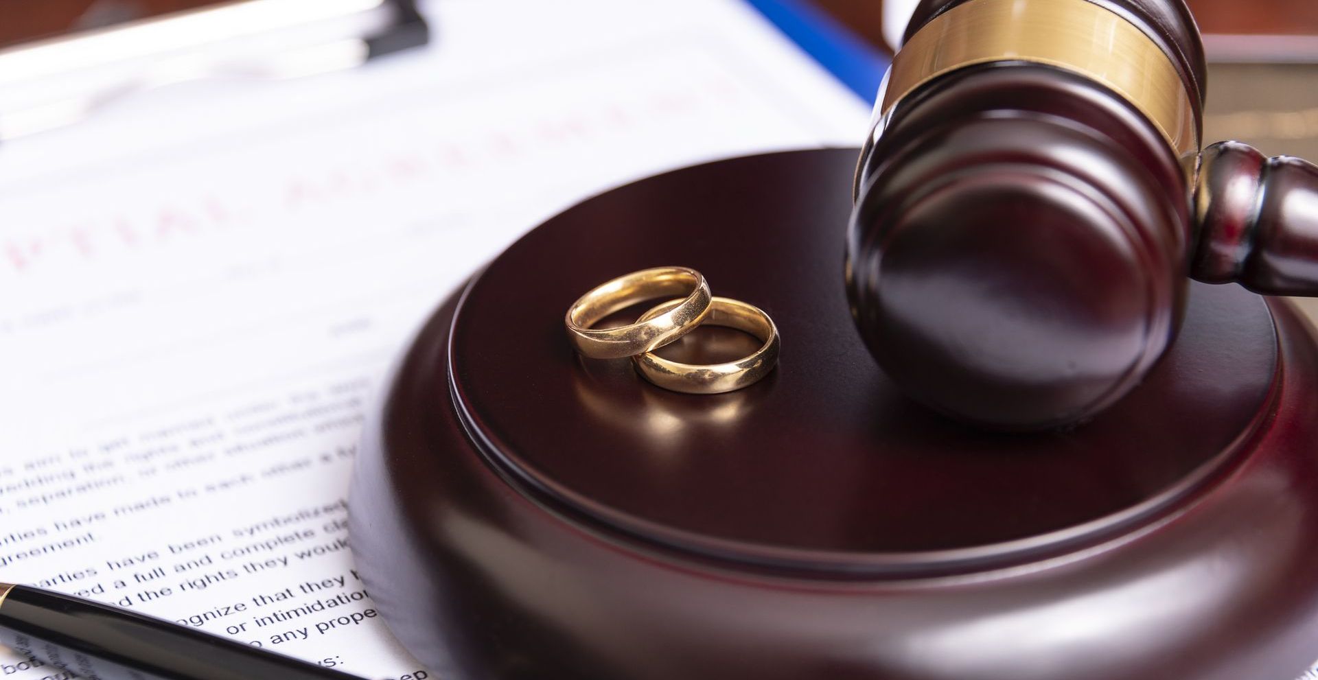 A pair of wedding rings are sitting on top of a judge 's gavel.