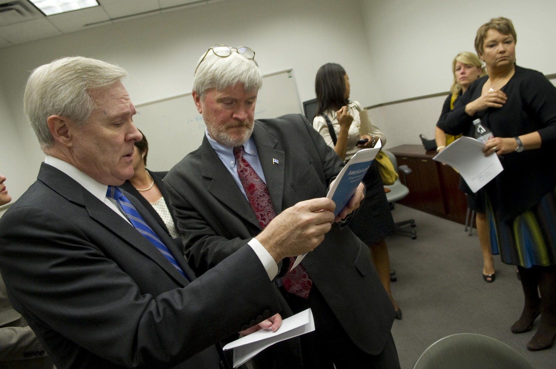 A man in a suit and tie is reading a book