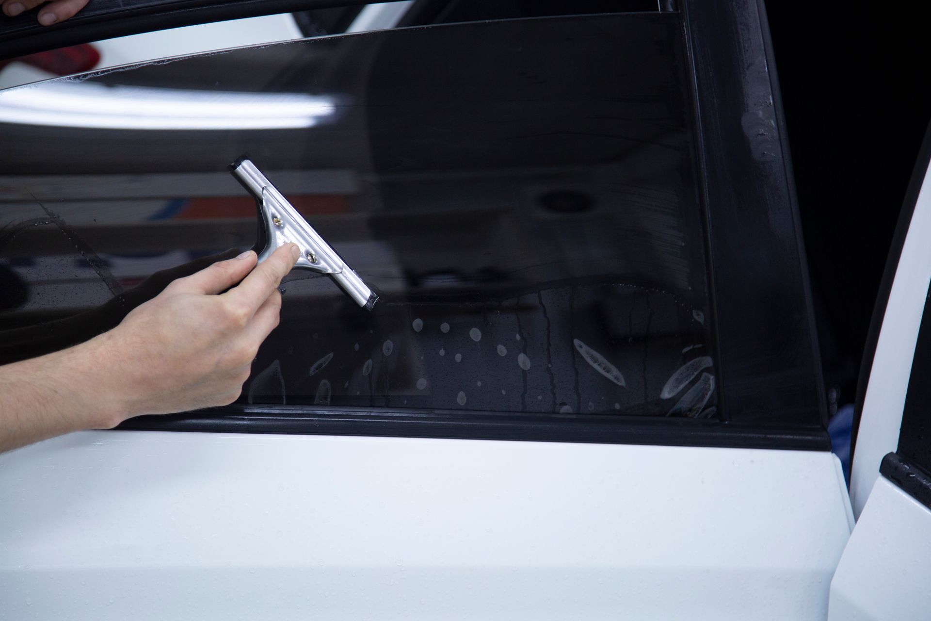 a person is cleaning a car window with a squeegee