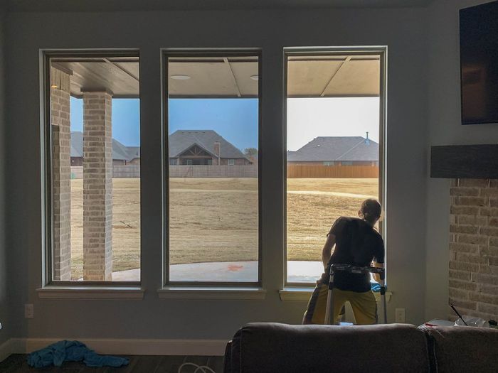 a man is cleaning a window in a living room