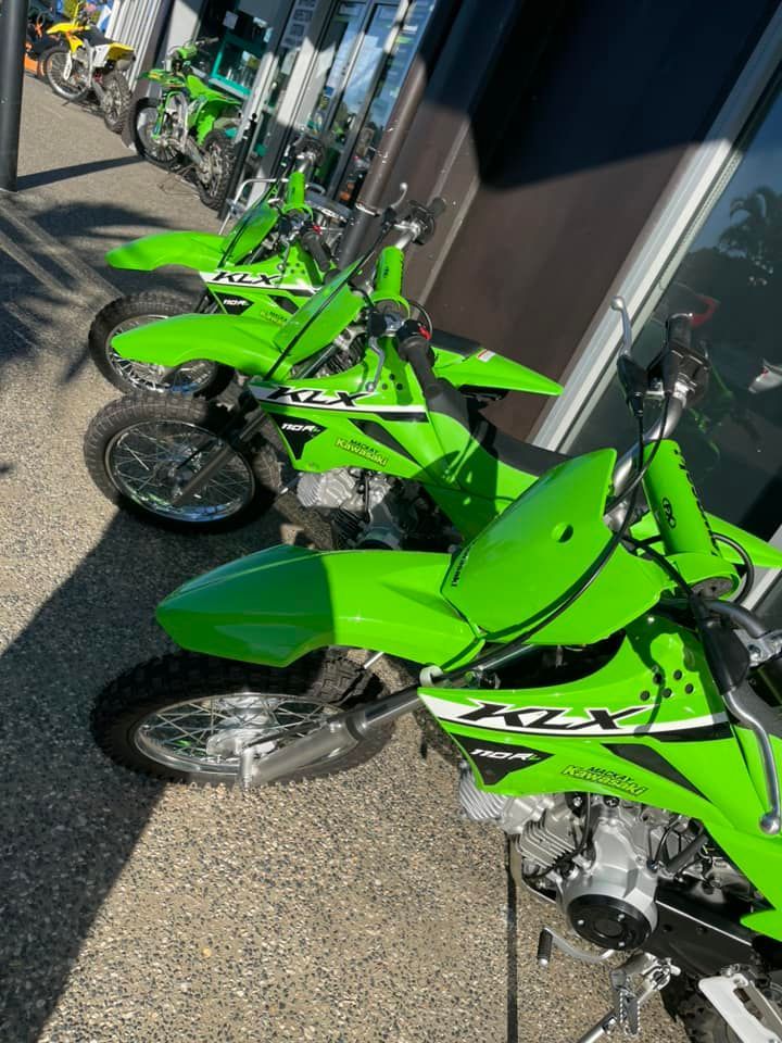 A Row of Green Dirt Bikes Are Parked in Front of a Building — Mackay Kawasaki in Mackay, QLD