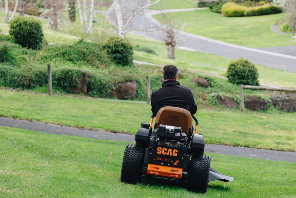 A Man is Riding a Lawn Mower on a Lush Green Lawn — Mackay Kawasaki in North Mackay, QLD