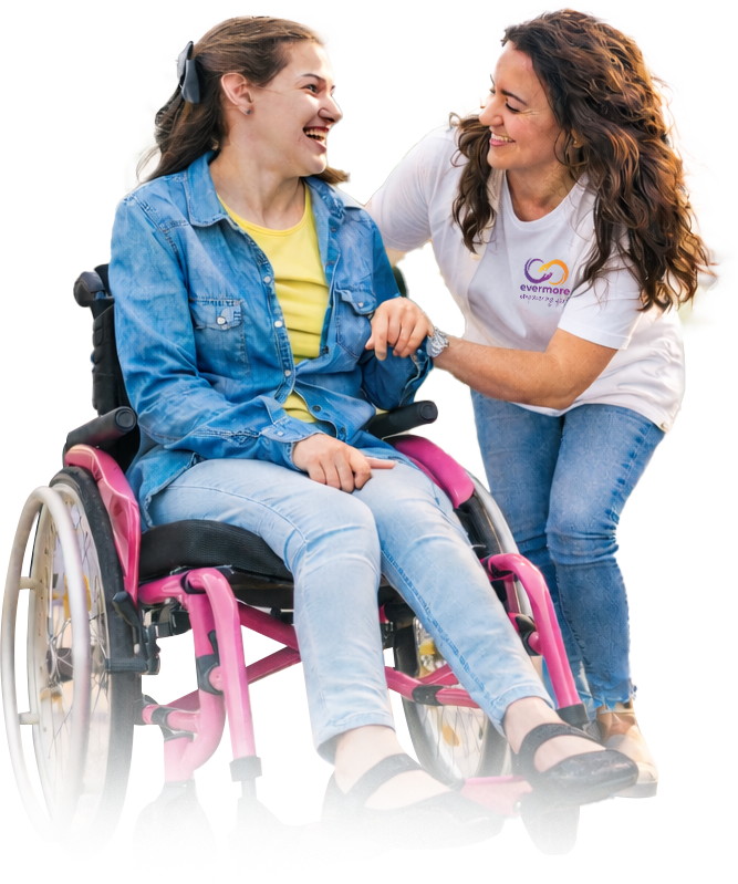 Woman in a wheelchair smiling with a helper against a white background