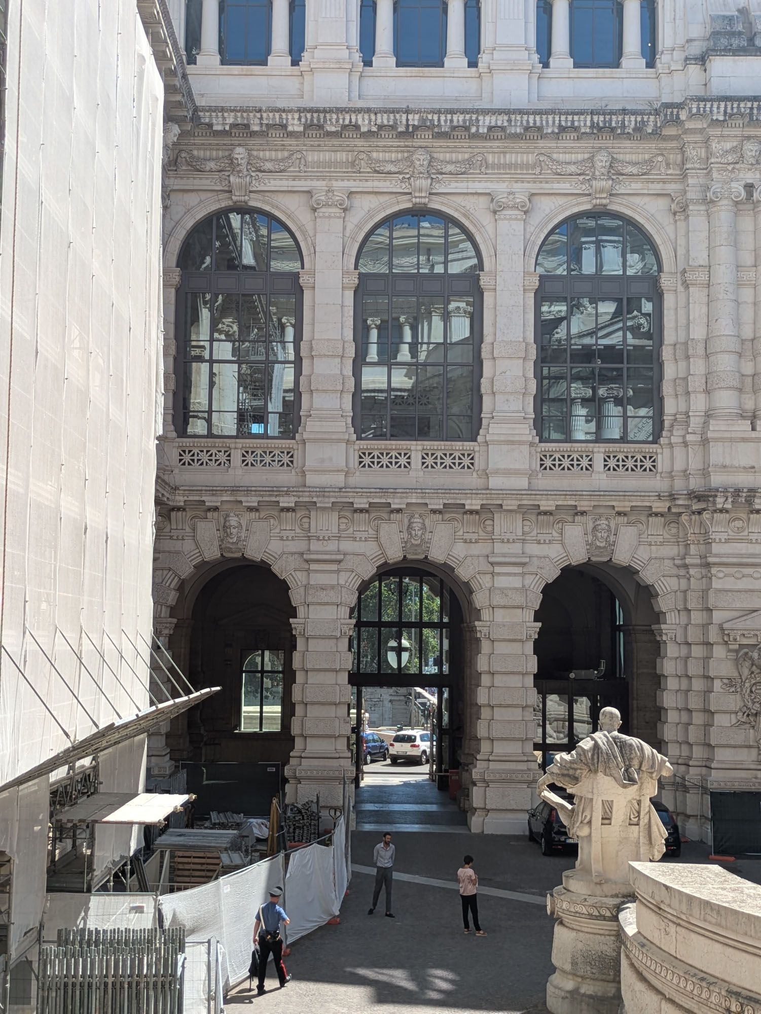Esterno di un edificio decorato con ingresso ad arco, grandi finestre e persone.
