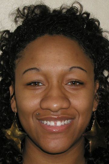A woman with curly hair is smiling for the camera