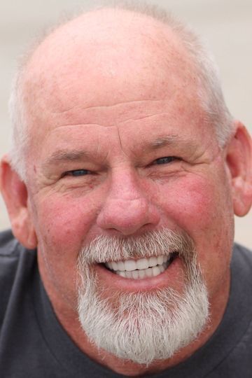 A man with a beard and mustache is smiling for the camera.