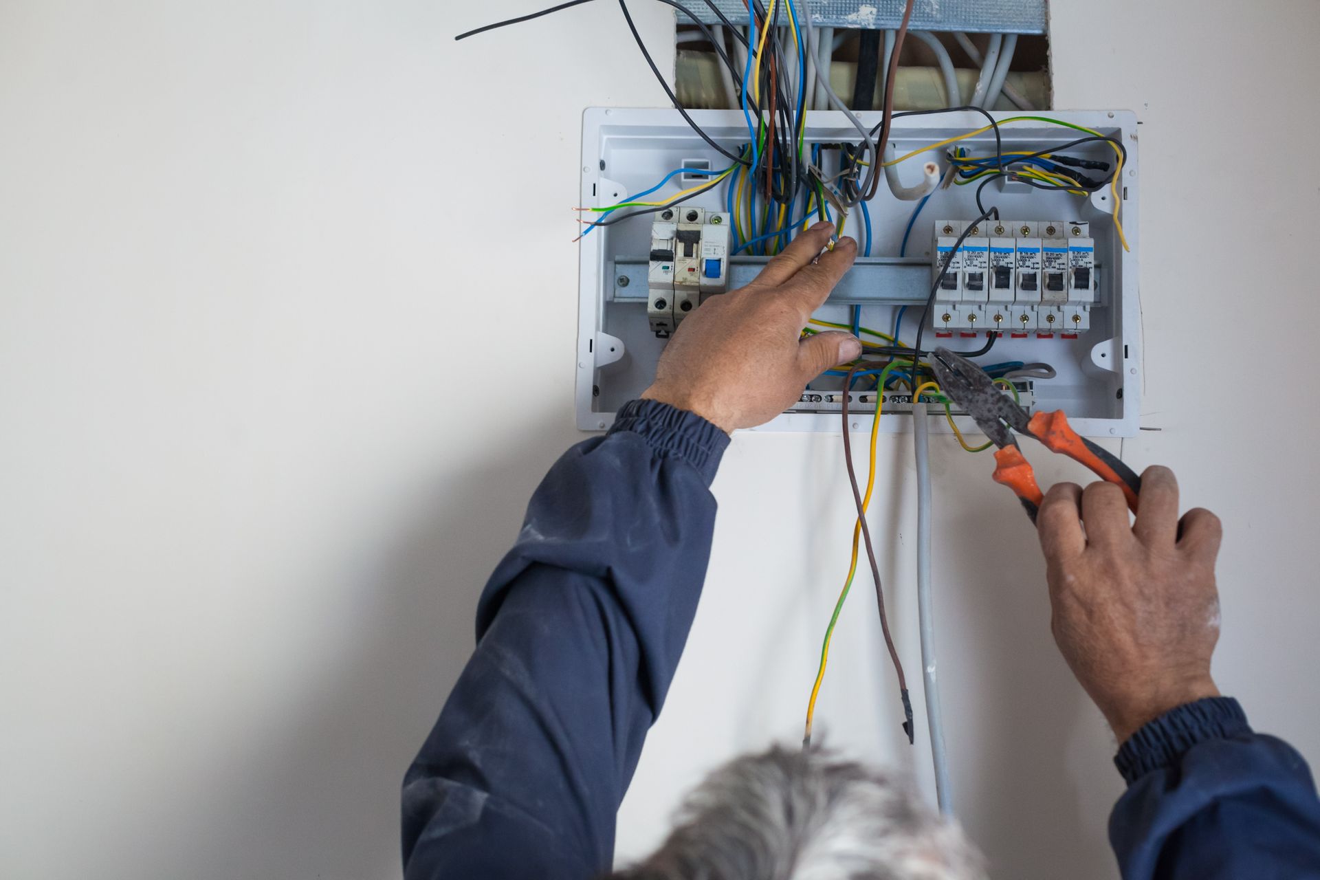Licensed electrician repairing residential circuit breaker panel ensuring safe power distribution.