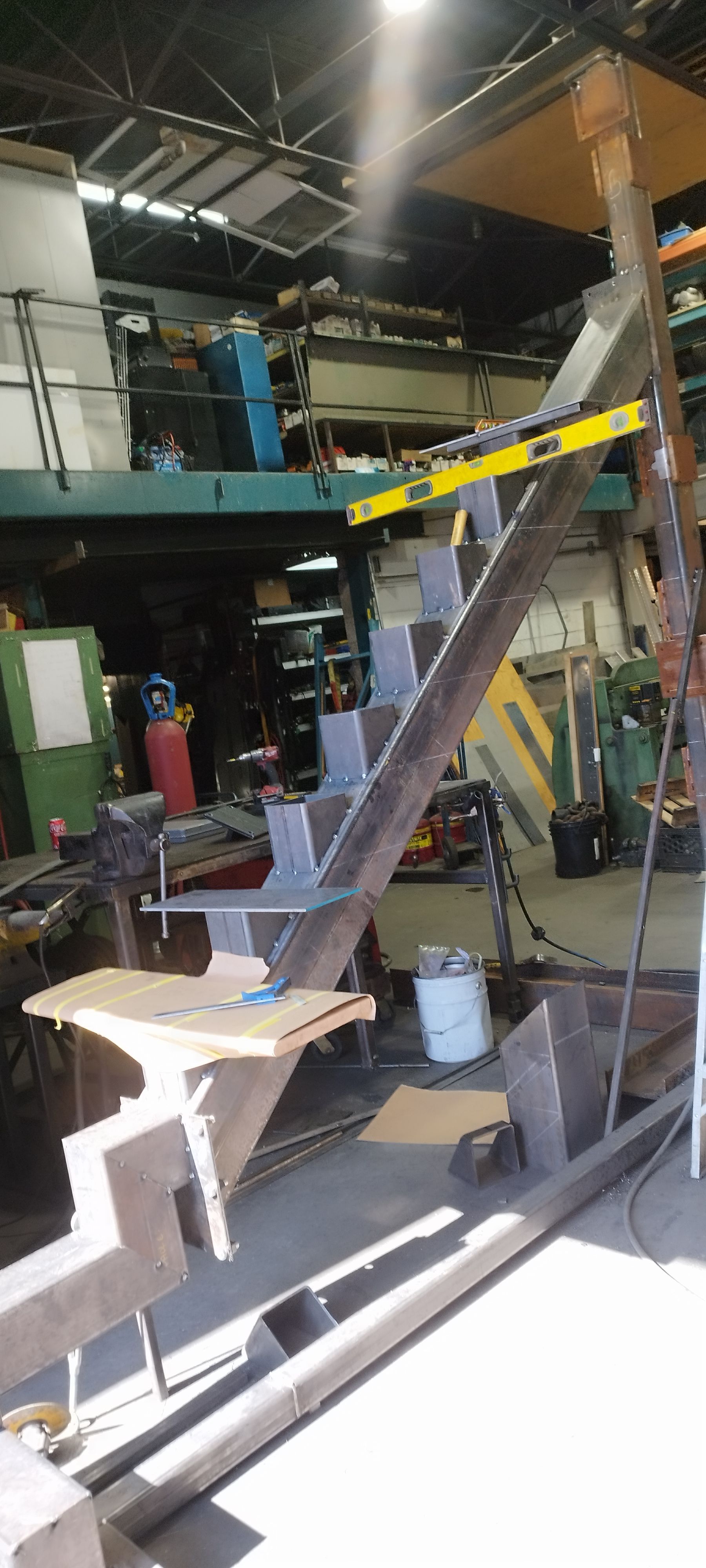 Poutres métalliques dans un atelier avec un niveau attaché, peut-être un escalier en construction.