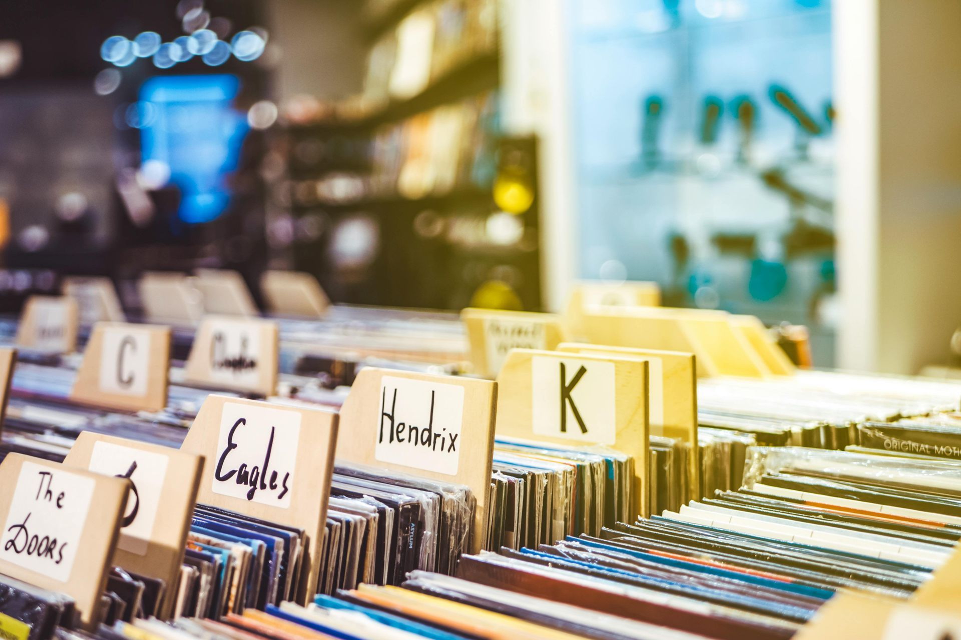 Record store shelves with labeled record albums, including The Doors, Eagles, and Hendrix.
