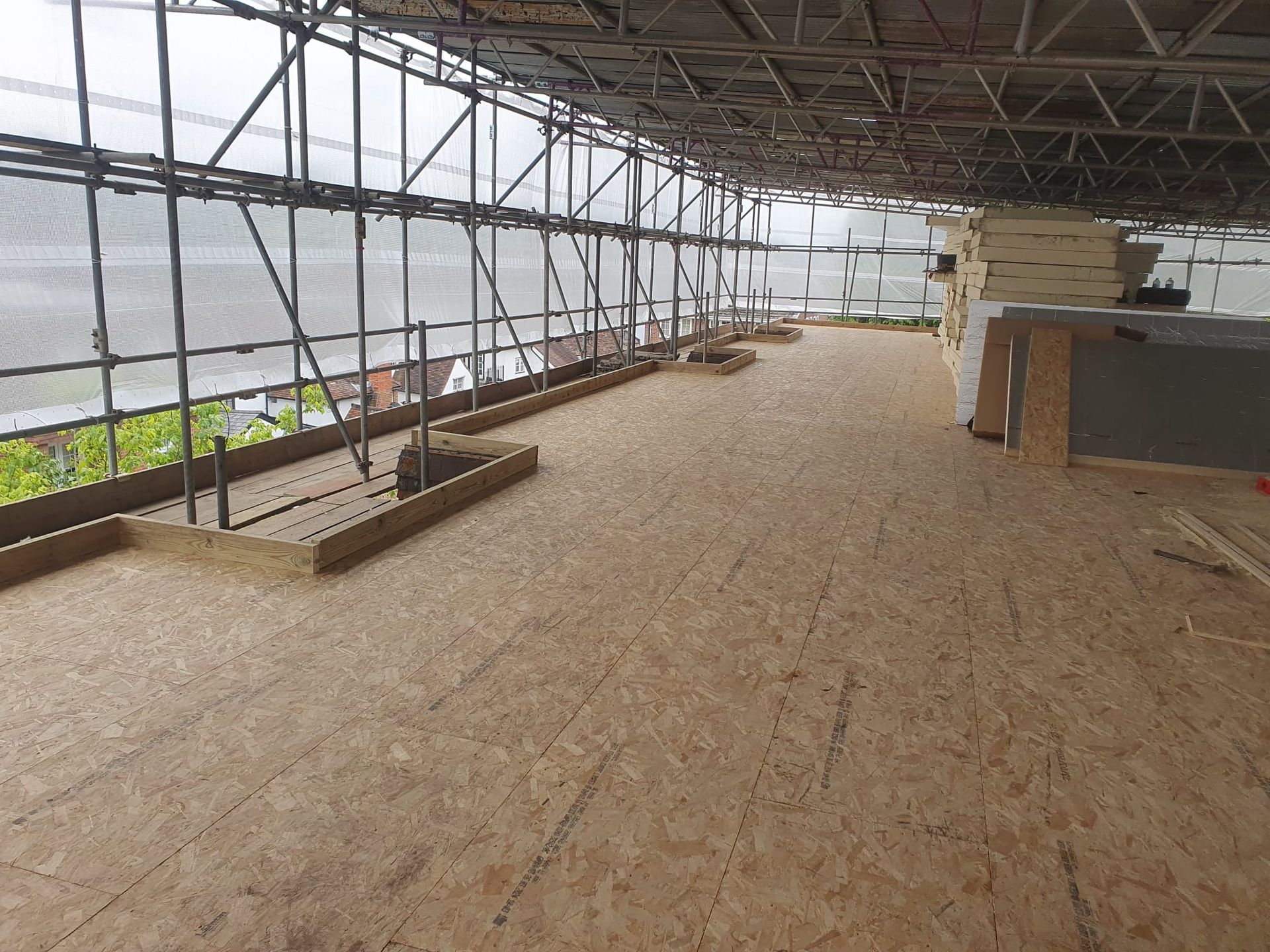 A large empty room with scaffolding and a wooden floor