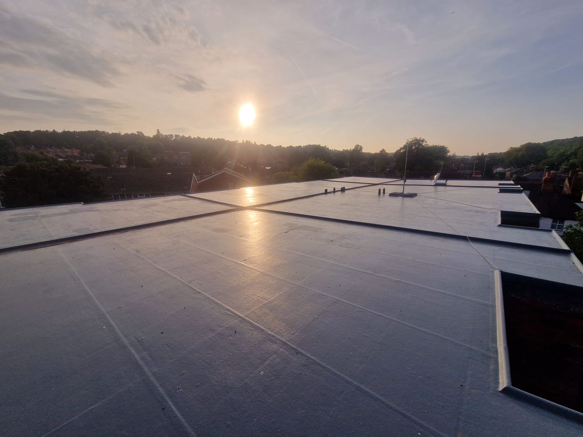 The sun is shining on the roof of a building.