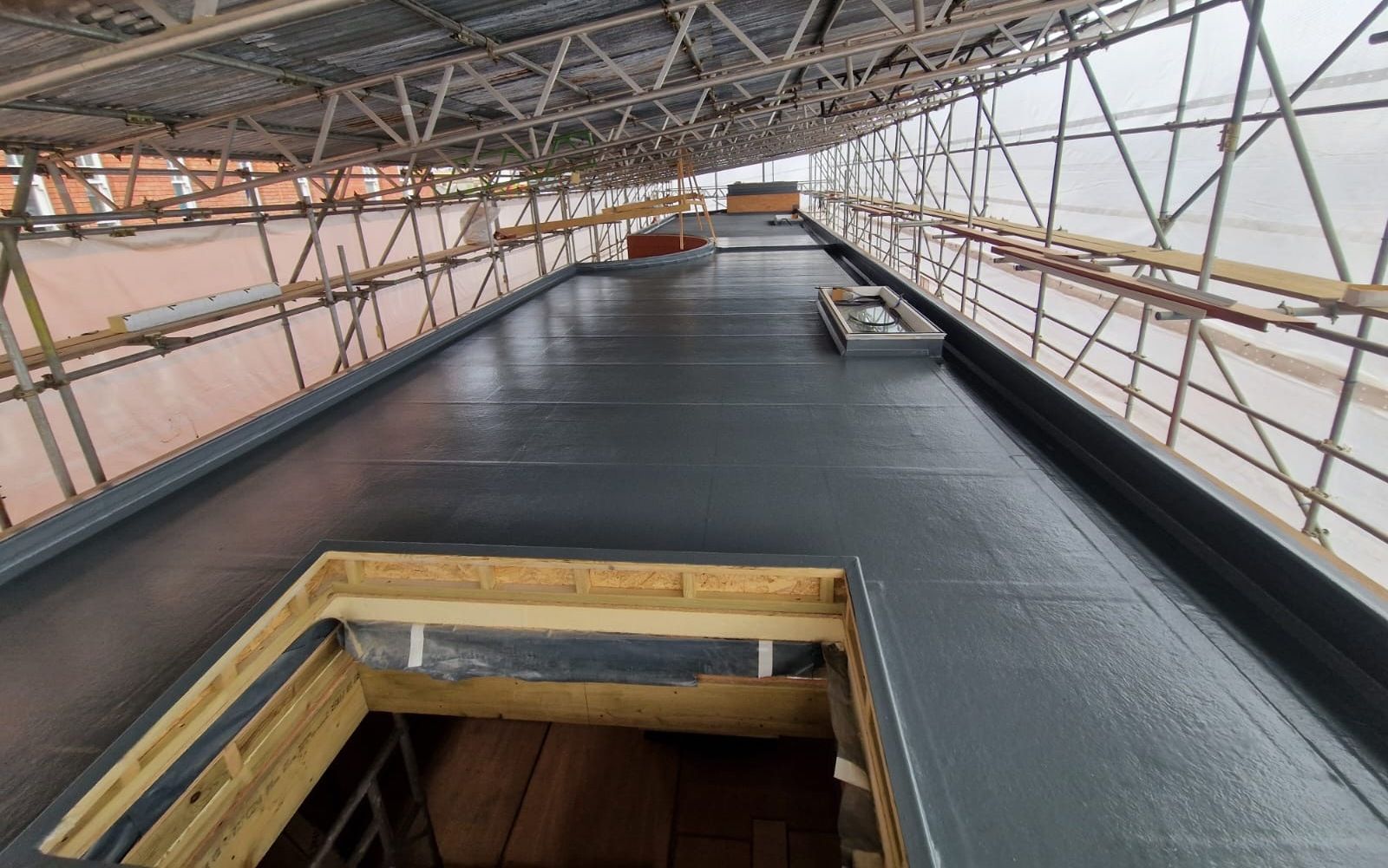 The roof of a building is covered in scaffolding.
