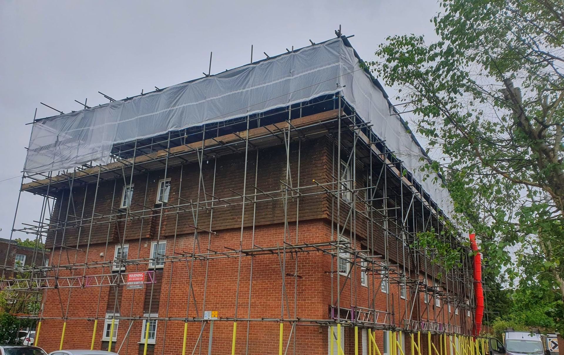 A large brick building is being built with scaffolding around it.