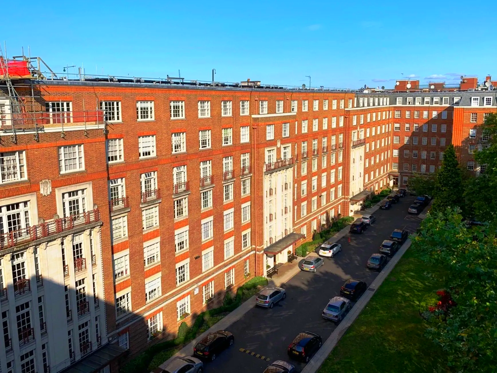 An aerial view of a brick building with cars parked in front of it.