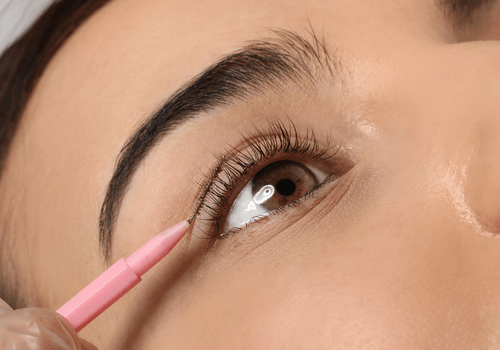 Eine Nahaufnahme einer Frau, die sich einen Eyeliner aufträgt.