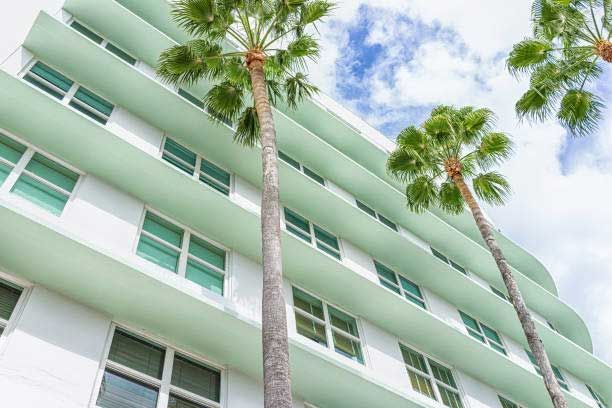 A tall building with palm trees in front of it.