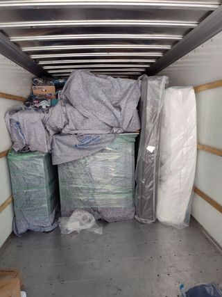 Packed furniture and wrapped items inside a moving truck trailer