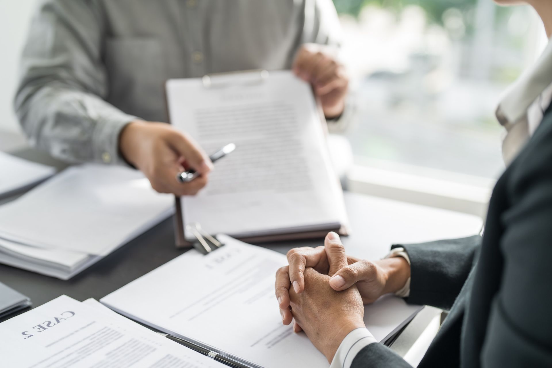 A man and a woman are sitting at a table looking at papers.