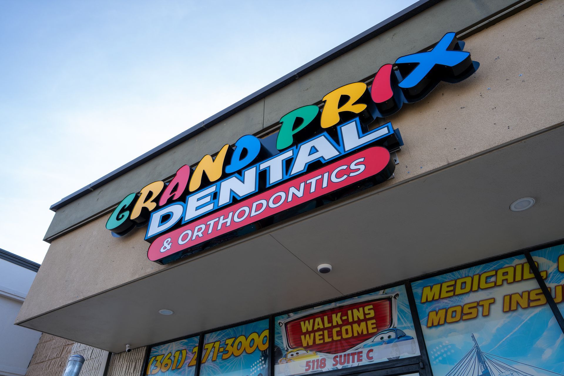 Grand Prix Dental Orthodontics storefront sign on a beige building under a blue sky