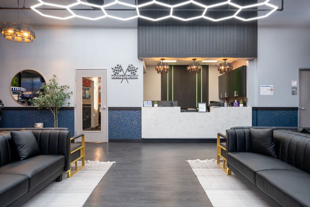 Modern waiting area with black sofas, geometric ceiling lights, and a reception desk