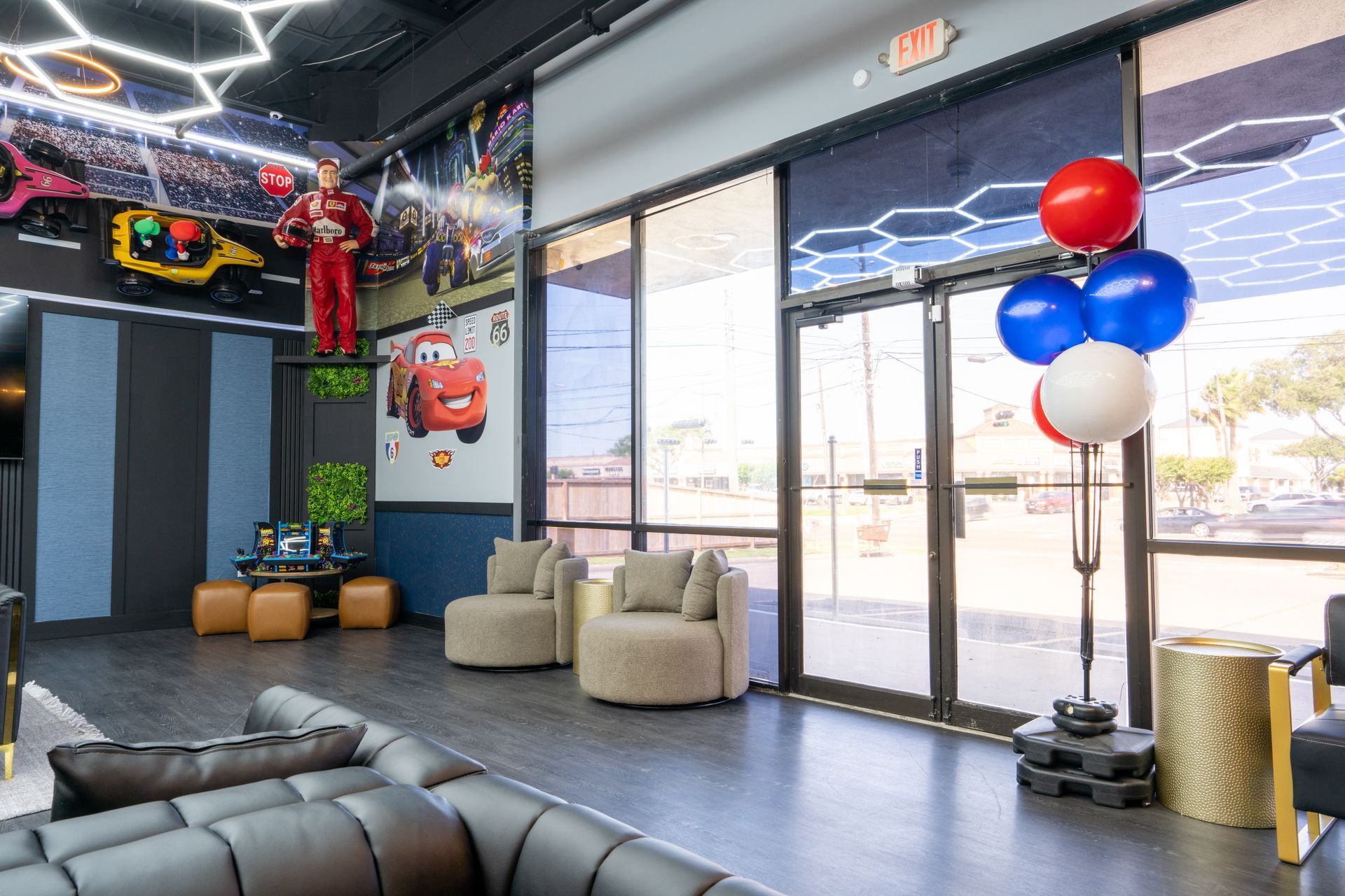 Modern office lobby with black seating, balloons, glass doors, and colorful wall art
