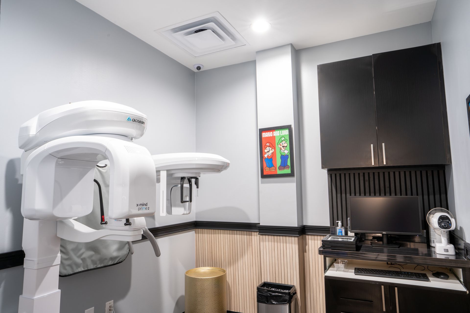 Dental exam room with panoramic X-ray machine, sink, cabinets, and countertop equipment