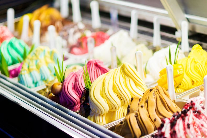 Une vitrine remplie de rangées de boules colorées de gelato artisanal aux saveurs variées.