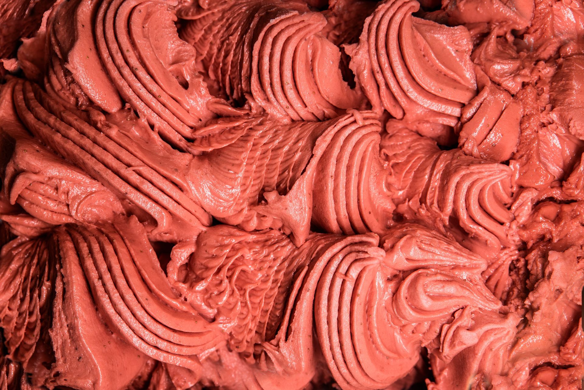 Close-up of thick red frosting swirled into textured ridges