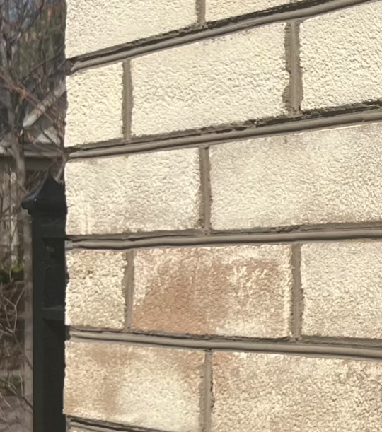 a man is pointing at a stone wall