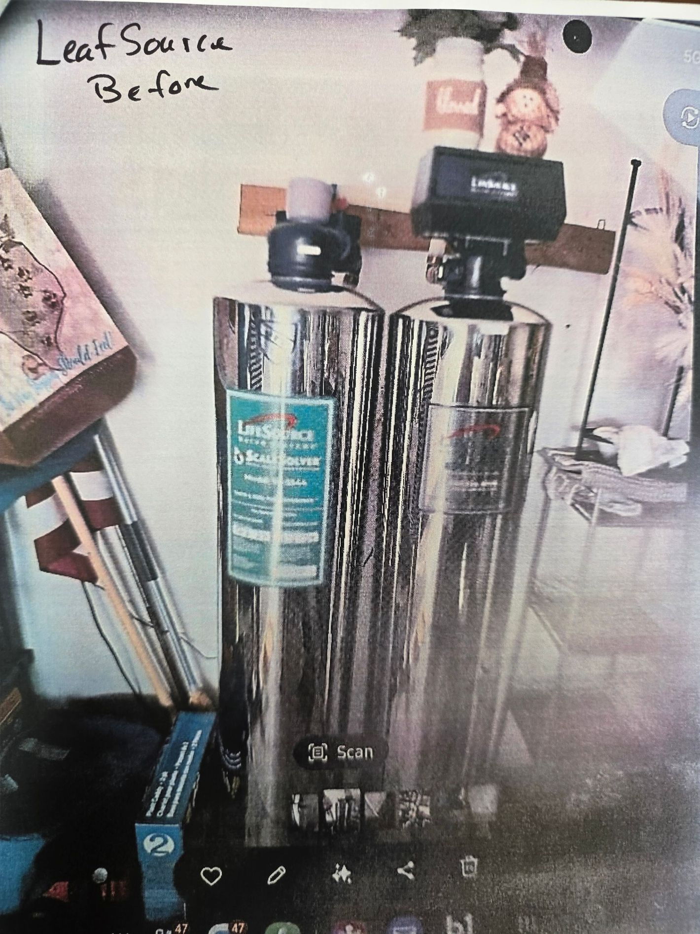 Stainless steel water filter with black lid on a shelf, labeled “Leaf Scale Before.”